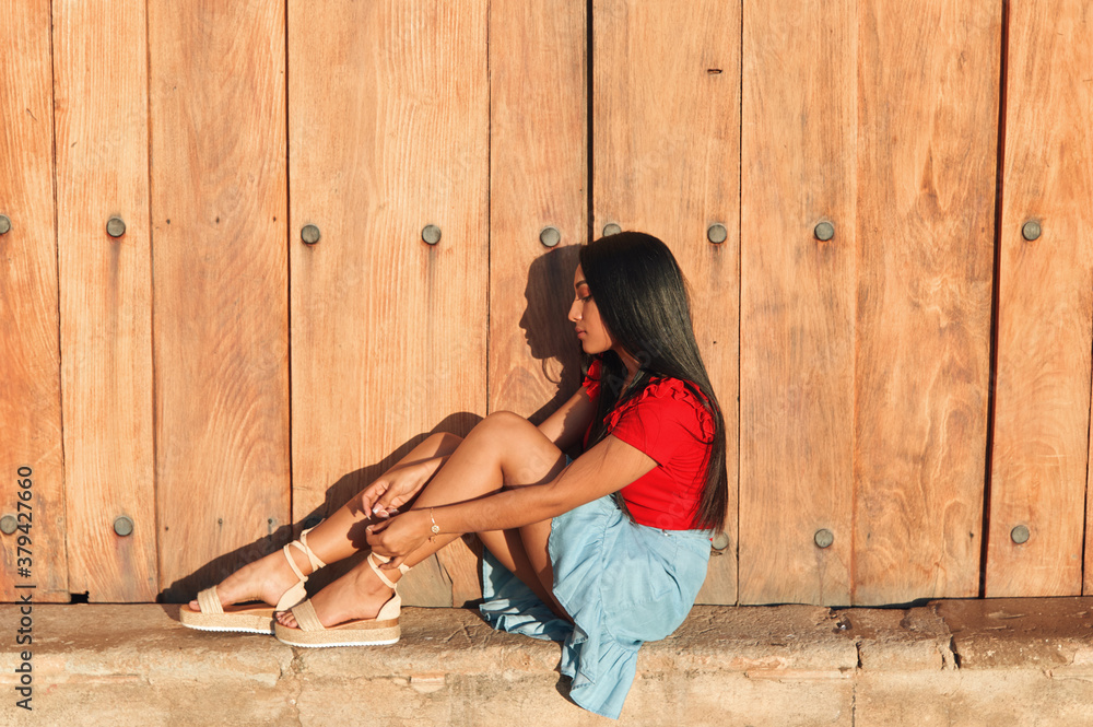 A young female on a summer day wearing a red shirt bright blue