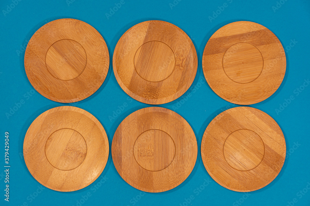 Bamboo saucers arranged in various order, with space to insert letters of text