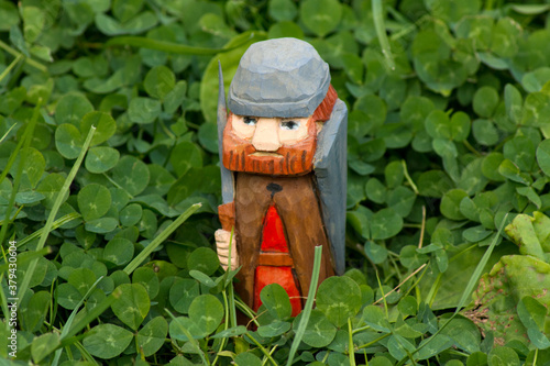 self-carved wooden figure in clover