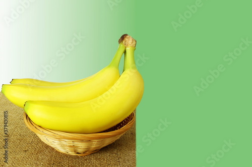 yellow banana fruit isolated in green background with taxt copy space photo