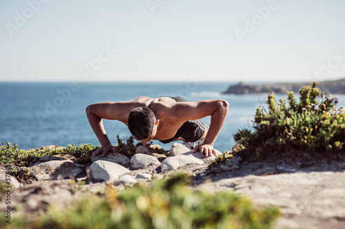 Fotografie hombre flexiones mar deporte joven no se ve la cara