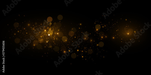 Transparent golden light effect. Magical sparkles isolated on black background.