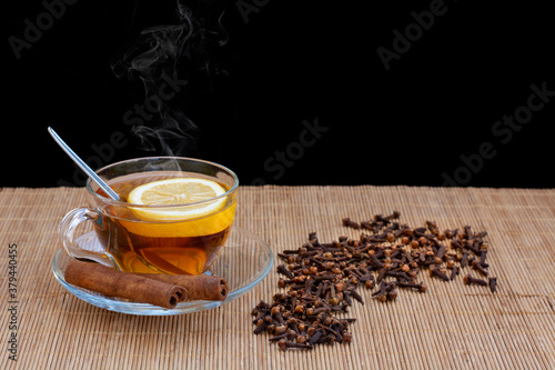aromatik sıcak tarçın çayı ve ahşap masa üzerinde karanfil tohumları