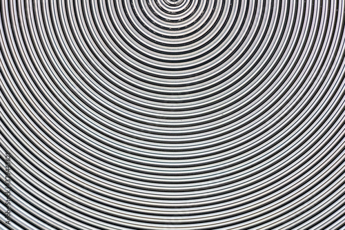 Aluminum metal surface with spiral pattern texture closeup photo background.