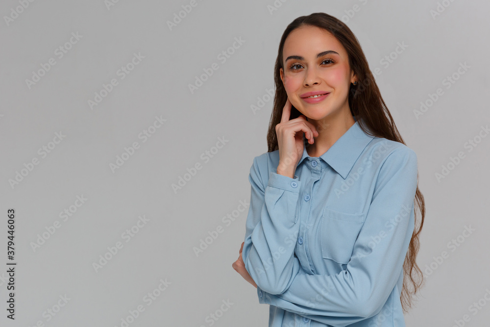 Portrait of beautiful young Caucasian woman having doubtful expression, looking at camera in indecisiveness, holding her chin,trying to find best solution. Body language concept. Portrait of beautiful young Caucasian woman having doubtful expression, looking at camera in indecisiveness, holding her chin,trying to find best solution. Body language concept.