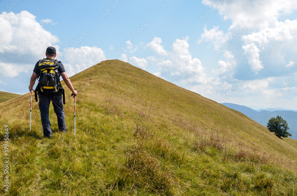 Hiker with a backpack before the last step to the top of the mountain. Leisure activity in mountains. Hiking sport