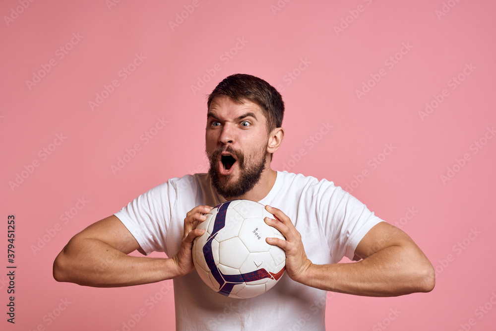 Man with a soccer ball on a pink background energy gesticulate with his hands coach emotions model