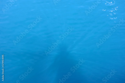 Azurblaues Meer mit Schatten von Menschen