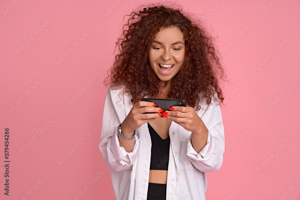 Excited young girl attend cool concert record video for her vlog, stream music festival online via social media, holding smartphone and looking at display with amazed happy face to take shot Excited young girl attend cool concert record video for her vlog, stream music festival online via social media, holding smartphone and looking at display with amazed happy face to take shot
