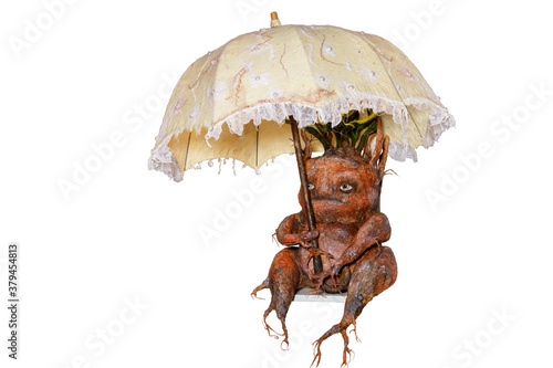 Foto Mandrake root sits hiding under an umbrella, scary, funny, carved from wood