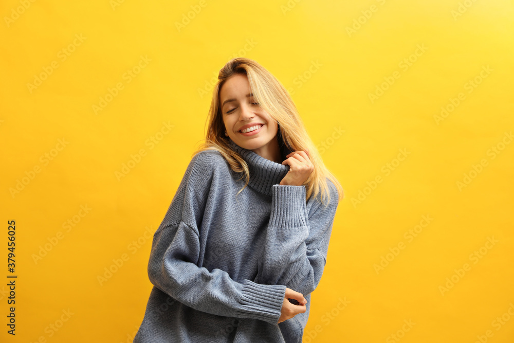 Beautiful young woman wearing knitted sweater on yellow background Beautiful young woman wearing knitted sweater on yellow background