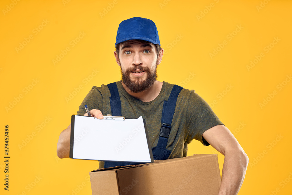 Worker male courier delivering boxes packaging documents yellow background Worker male courier delivering boxes packaging documents yellow background