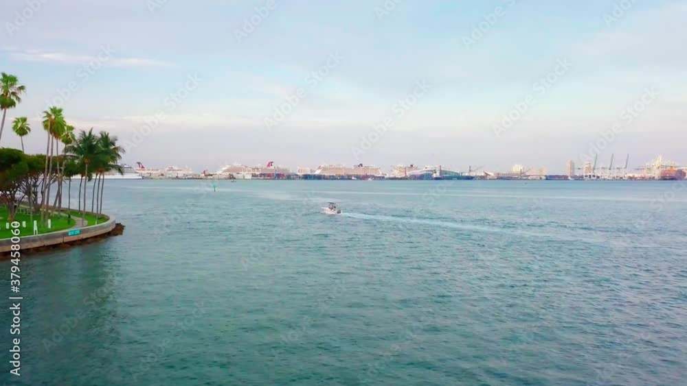 Aerial view towards a boat, driving at the coast the Brickell key, during sunrise, in Miami, Florida, USA - dolly, drone shot Aerial view towards a boat, driving at the coast the Brickell key, during sunrise, in Miami, Florida, USA - dolly, drone shot