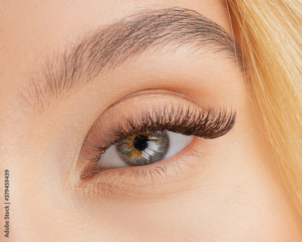 Eyelash extension procedure. Beautiful female eyes with long lashes closeup Eyelash extension procedure. Beautiful female eyes with long lashes closeup
