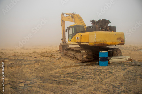 Excavator in the deserted road on the foggy morning,