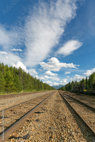 Railroad Tracks leading into distant snow capped mountains in Canada
