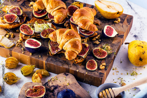view of delicious freshly baked croissants with figs  pears  nuts and honey