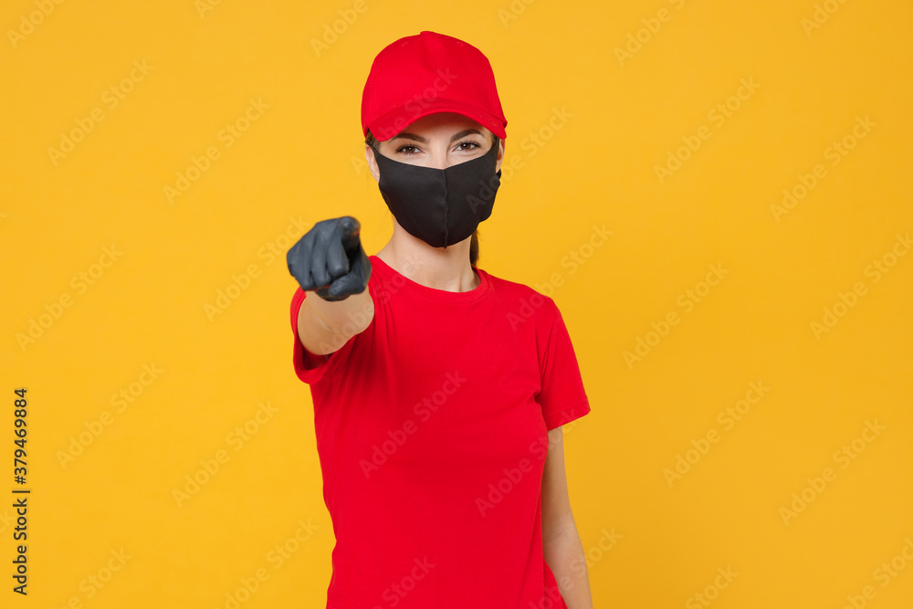 Delivery employee woman in red cap blank t-shirt uniform protect face mask gloves working courier in service during quarantine coronavirus covid-19 virus isolated on yellow background studio portrait. Delivery employee woman in red cap blank t-shirt uniform protect face mask gloves working courier in service during quarantine coronavirus covid-19 virus isolated on yellow background studio portrait.