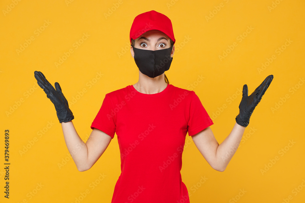Delivery employee woman in red cap blank t-shirt uniform protect face mask gloves working courier in service during quarantine coronavirus covid-19 virus isolated on yellow background studio portrait. Delivery employee woman in red cap blank t-shirt uniform protect face mask gloves working courier in service during quarantine coronavirus covid-19 virus isolated on yellow background studio portrait.