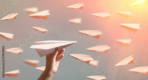 Paper plane flying in the opposite direction to other planes. Concept of individuality.