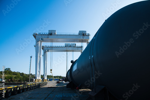 Bild auf Leinwand Harbor gantry crane moving a tank container