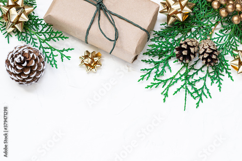 Long white Christmas banner with fir tree branches, gift box in craft paper and red decorations on white background. Copy space for your design. Christmas and New Year concept.