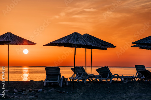 Beach umbrellas at sunrise © amelie