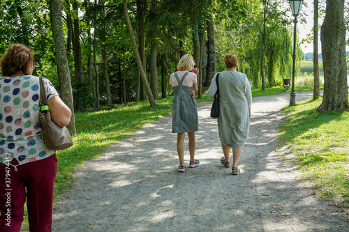 Fototapeta Naklejka Na Ścianę i Meble -  A group of Mature tourists walking in the  Park.