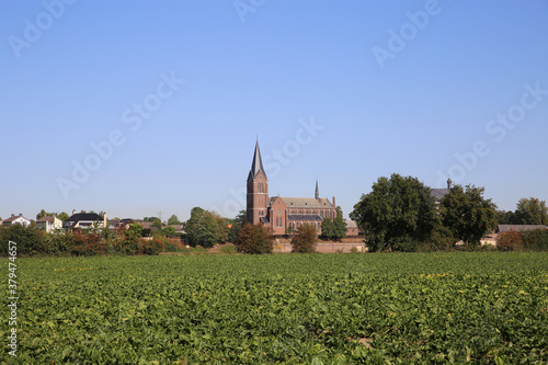 View over green agriculture field on dutch village with church in autumn - Kessel, Netherlands