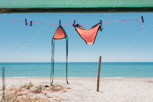 Photography Wet swimsuit on rope with pins on the beach