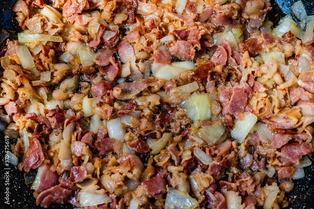 Fried bacon with onions in the frying pan Fried bacon with onions in the frying pan
