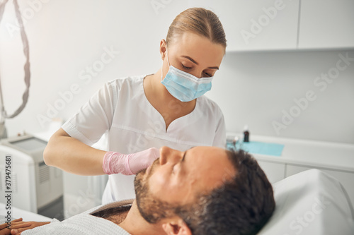 Unshaven young man receiving injectable skincare treatment