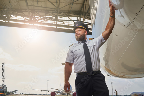 Photography Professional pilot near his plane in the airport