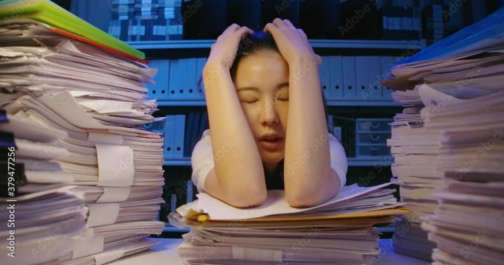 Young asian student woman dropping document on desk cover with stack of paperwork. Alone teen girl exhausted, tired and and lay down on pile of paper sheet while studying hard at late night.