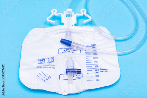 Sterile Urinary Drainage Bag with Anti-Reflux Tower isolated on blue background. © bjphotographs
