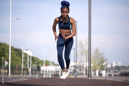 young black fitness woman running in stadium, do exercises, workout, lead healthy lifestyle. jogging