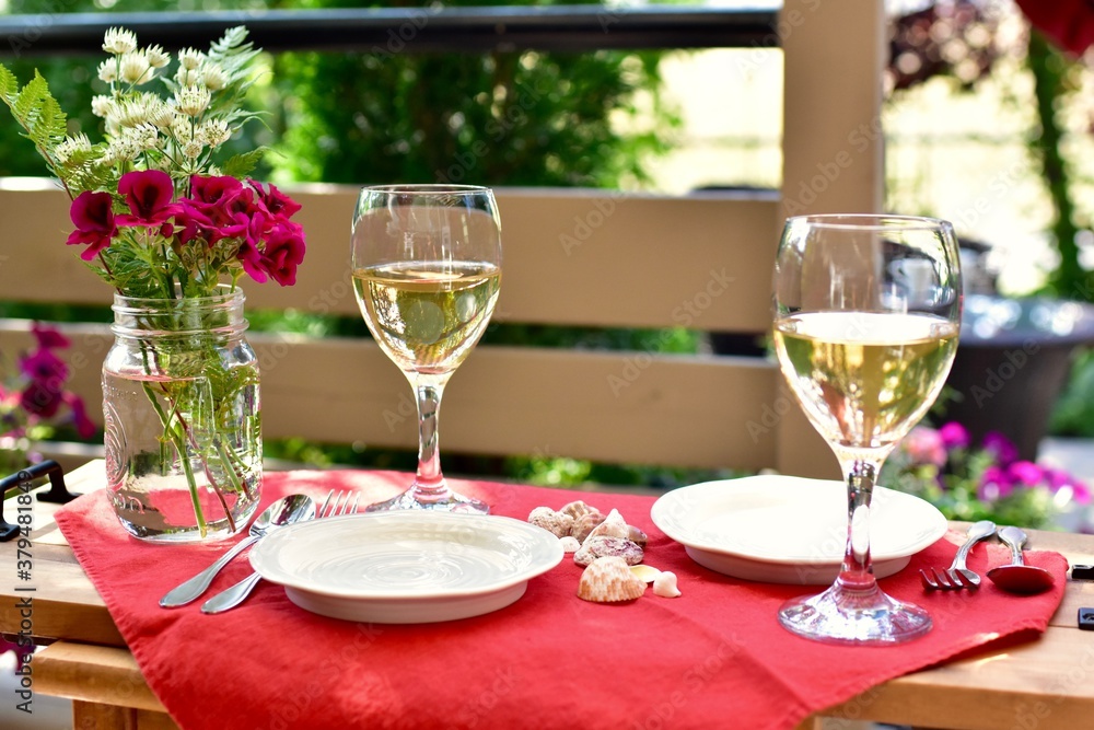 Outdoor al fresco patio table with beautiful place settings for relaxing dining on a warm summer evening Outdoor al fresco patio table with beautiful place settings for relaxing dining on a warm summer evening