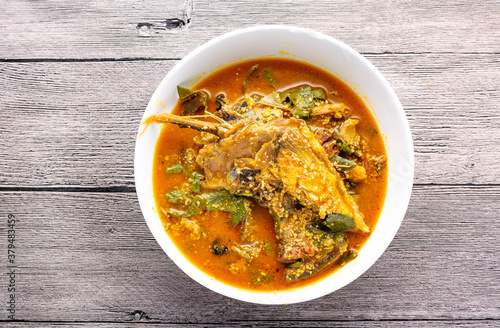 Oha soup with beef in a white ceramic plate and wooden background. Flatlay.