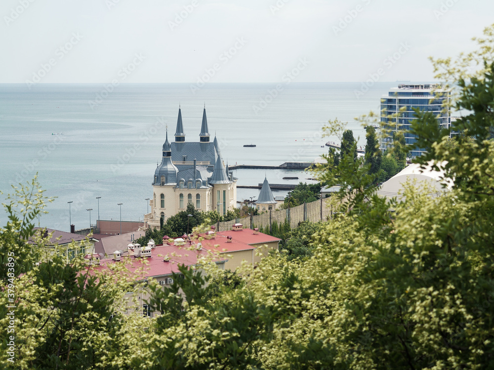 Odessa, Ukraine - July 16, 2018: panoramic view of the sea and houses, through the green crown of trees, summer mood and atmosphere, sunny day, blue sky, popular Ukrainian resort