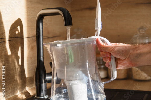 Fotografie Water filter jug in kitchen sink, filling up.