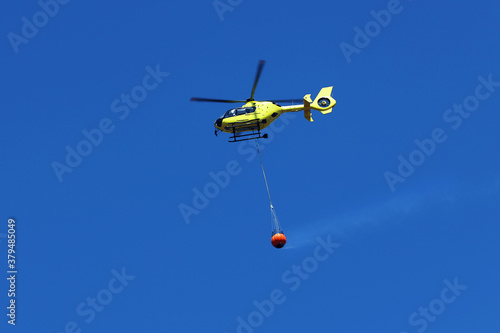 Firefighting helicopter carry water bucket to extinguish the fire or forest fire. 