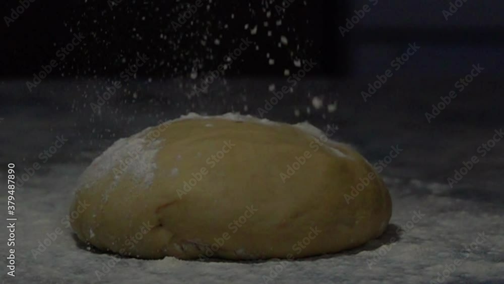 Flour sprinkling on the dough, slow motion Flour sprinkling on the dough, slow motion