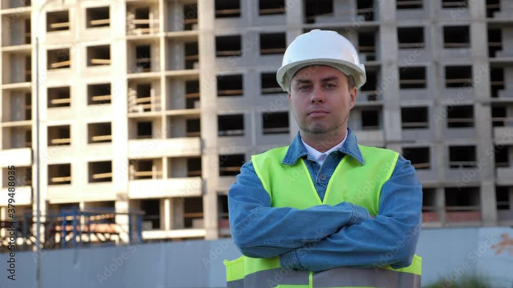 Worker with crossed hands in white protective helmet at construction site. Outdoors Worker with crossed hands in white protective helmet at construction site. Outdoors
