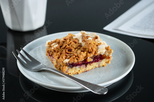 Cake on a plate, coffee and a magazine fragment