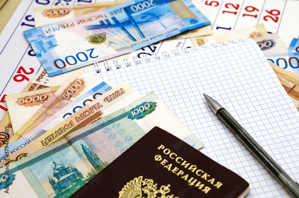 Russian passport on paper money. Notepad and pen on Russian banknotes. Russian passport on paper money. Notepad and pen on Russian banknotes.