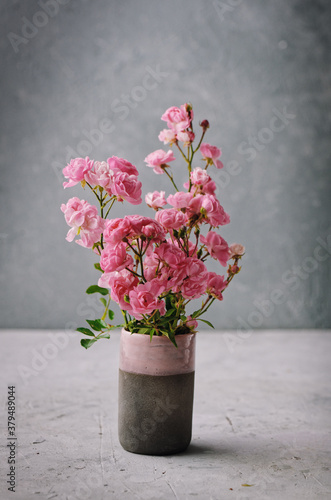 Floral background. Wild roses in a glass jar over stone background. Still Life Flowers. Nature.