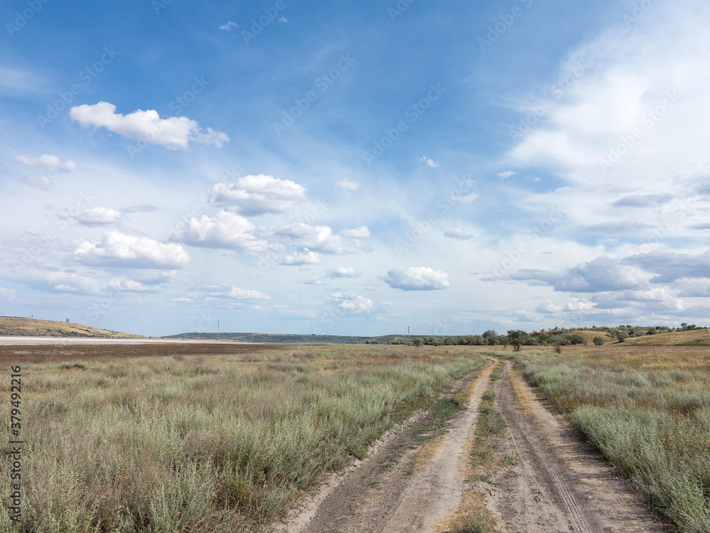 Rural landscape of blue sky in white clouds in the steppe near Odessa, hot summer day