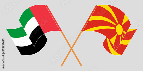 Crossed and waving flags of North Macedonia and the United Arab Emirates