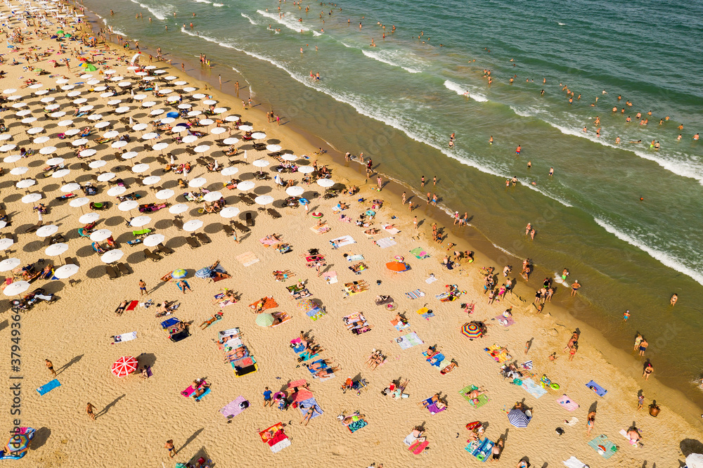 Aerial view from a drone. Beach with tourists, sunbeds and umbrellas. Travel background. Travel and vacation concept. Top view