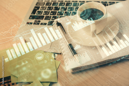 Double exposure of forex chart drawing and desktop with coffee and items on table background. Concept of financial market trading